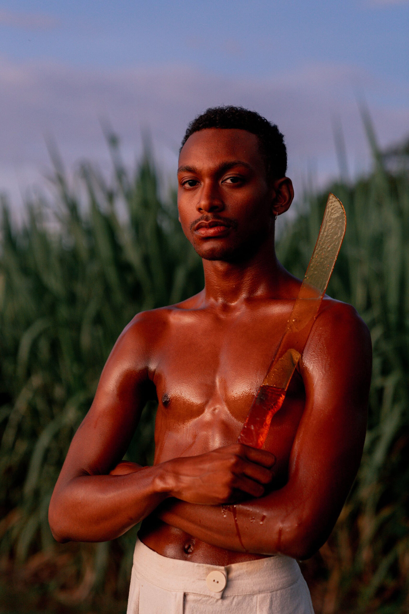 A man holding a sugar sculpture in the shape of a machete